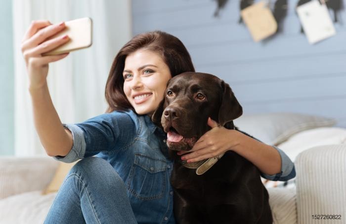 Girl taking selfie with dog