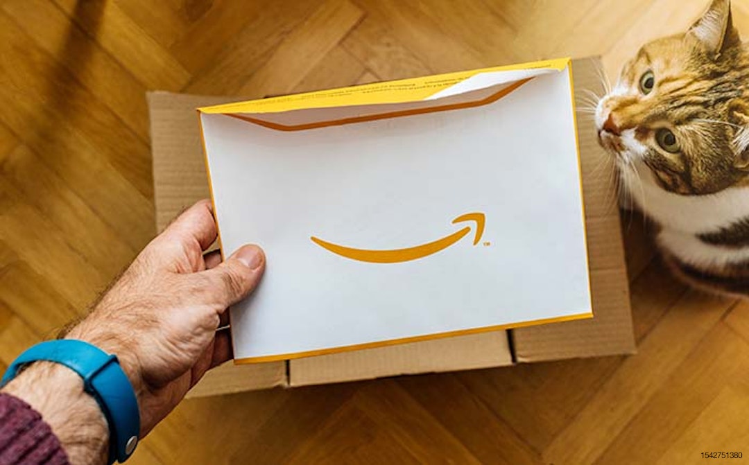 man opening Amazon box envelope cat helping