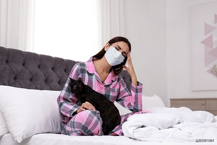 face-mask-woman-black-cat-bed-sick-COVID-pandemic.jpg