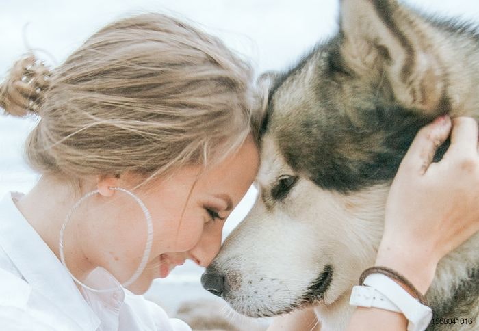 woman with dog touching foreheads
