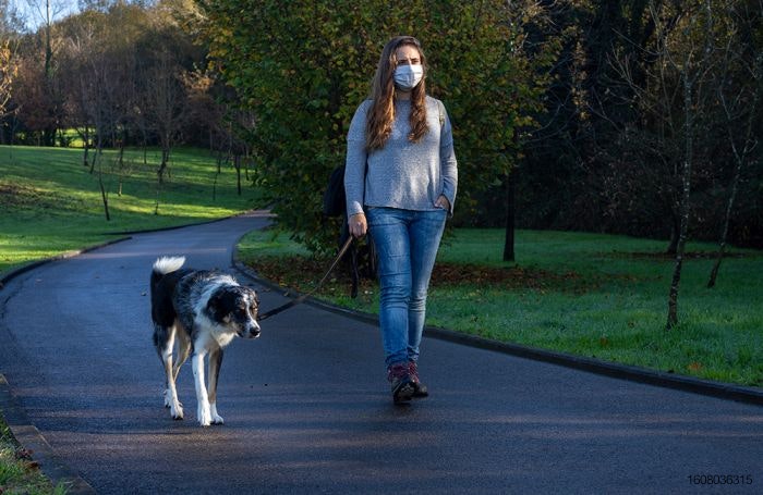 Woman-with-mask-on-walking-dog